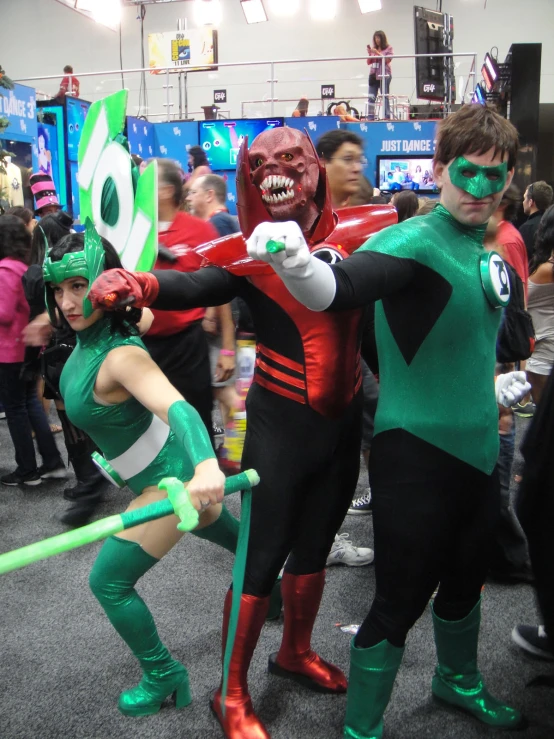 two people in costumes standing with a girl on one arm and another wearing green