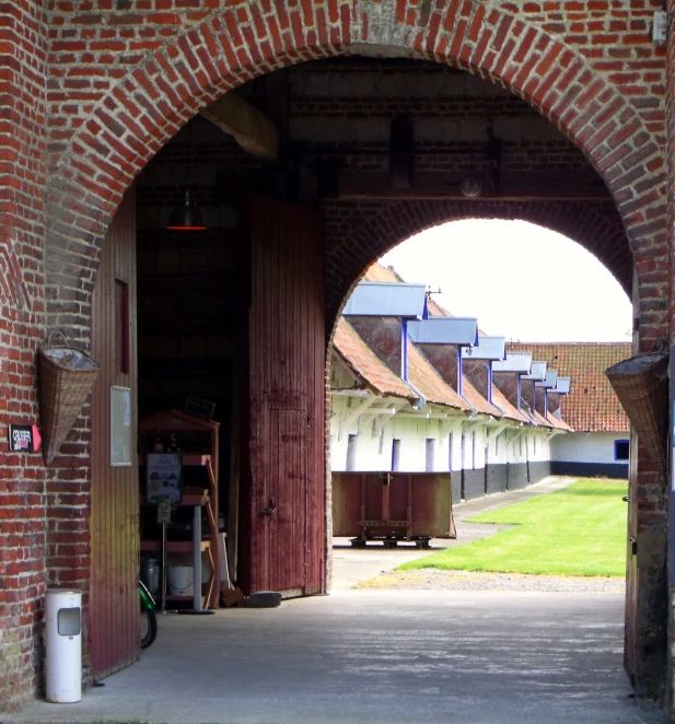 the back side of a brick covered tunnel with an arch