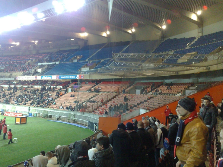 a crowded stadium has many spectators sitting on the grass