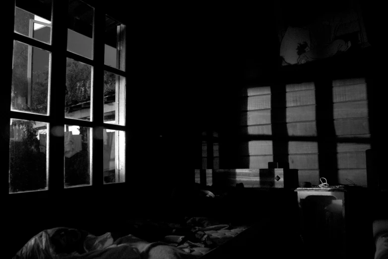 an empty bed in front of a window filled with light