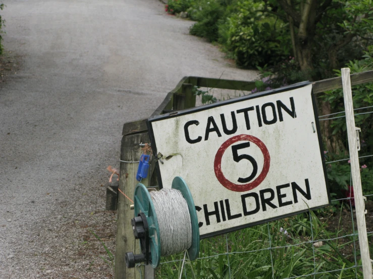 an outdoor sign with a white and black border that says caution 5 children