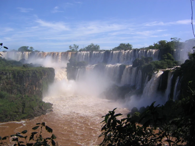 view from the ground looking over a river and waterfall