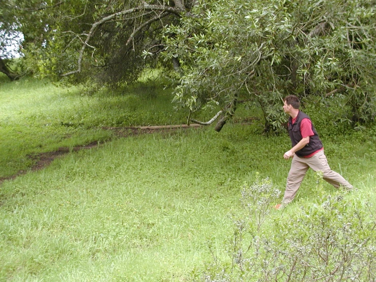 a young man walks through a wooded area