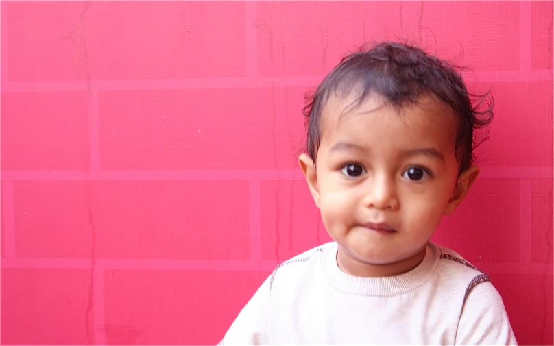 a little boy with a cute smirk and a t - shirt