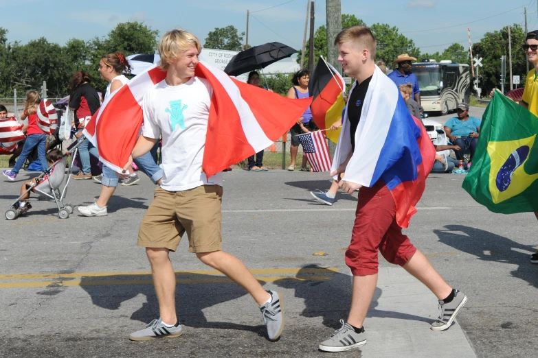 two men carrying flags walk through a crowd