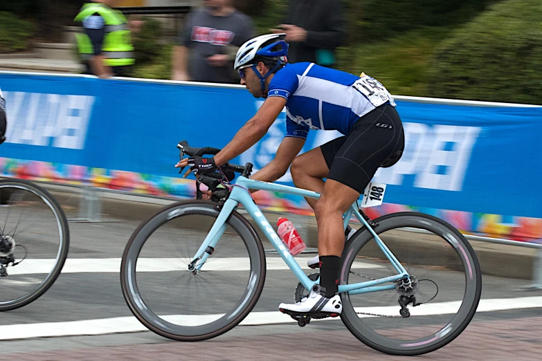 two men race down the street on their bicycles