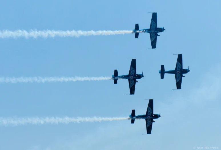 four planes flying in unison, making smoke trails