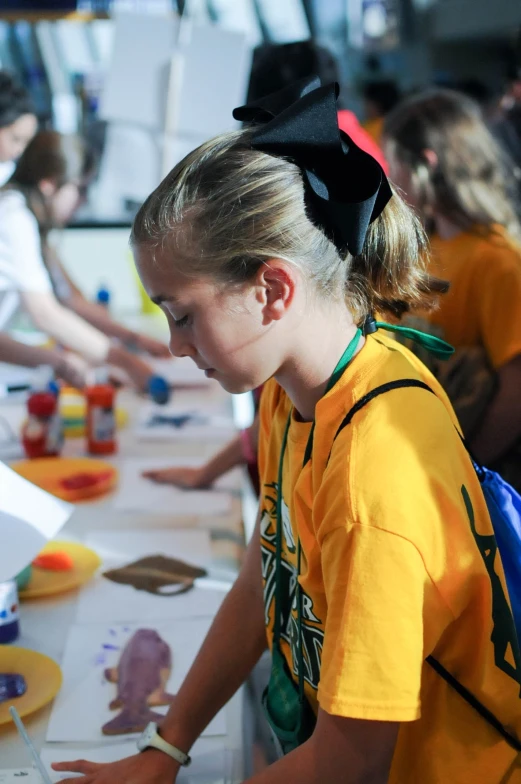 two s working on crafts in front of a crowd