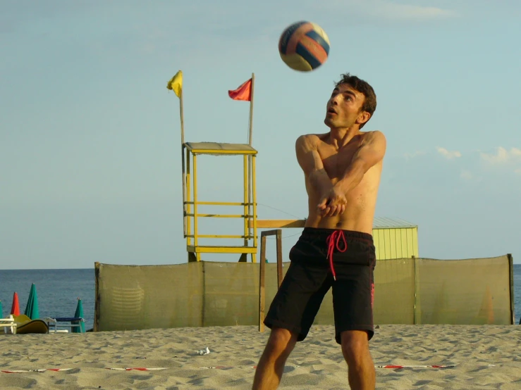 the man is playing volleyball on the beach