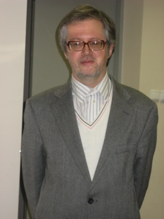 a man with glasses standing next to his door