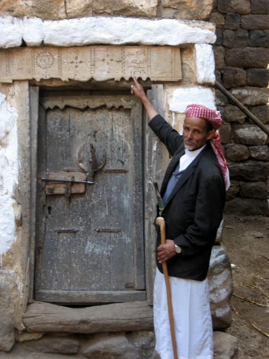 a man standing next to a large wooden door