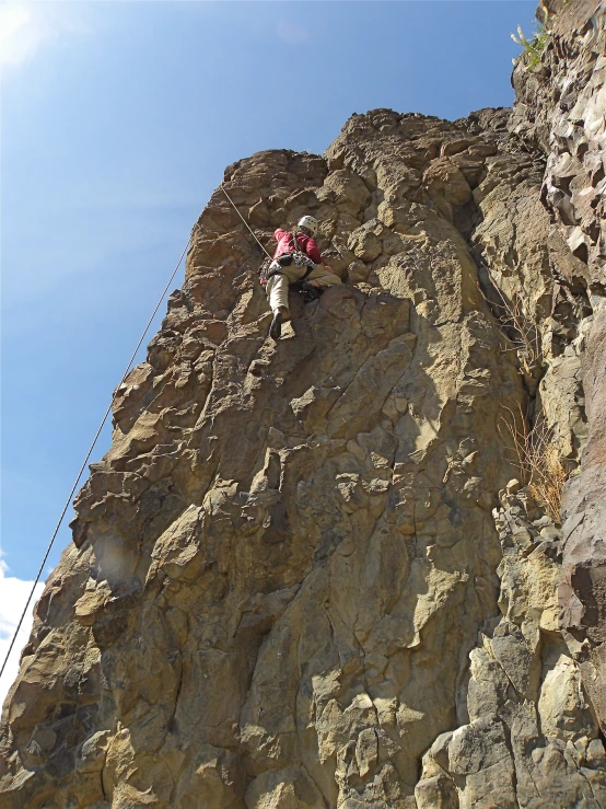 some people on a rope down a tall rock