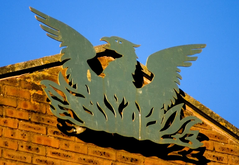 a bird cutout on top of the brick building