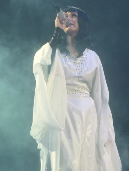 a woman in a white gown holding a microphone