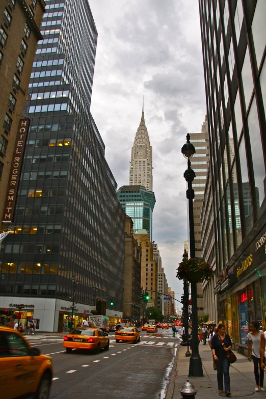 a couple of people walk in the streets next to buildings