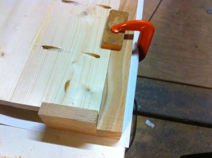 a wooden board with several nails stuck in it