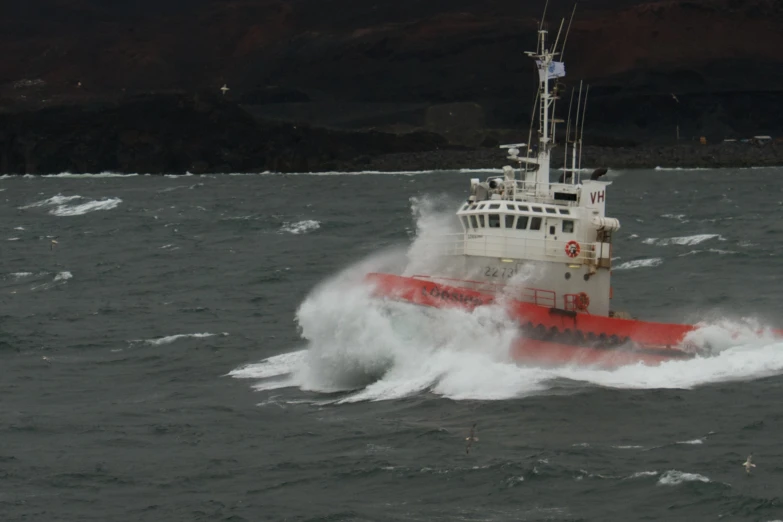 a red and white boat floating on top of a body of water