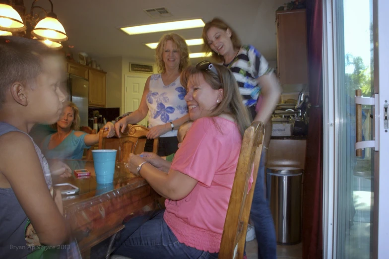 a group of women sitting around a kitchen table
