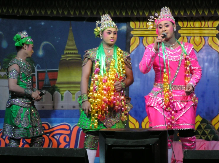 a group of dancers with pink outfits are performing on stage
