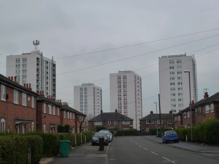 cars parked on the side of the road in front of a row of buildings