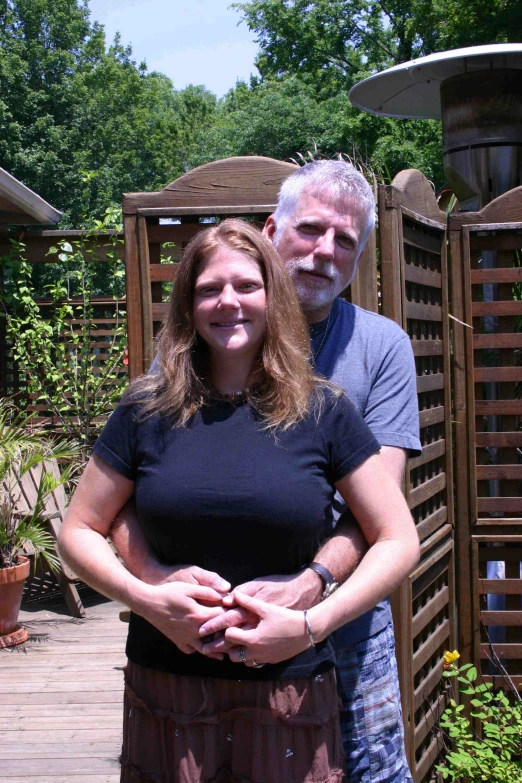 a man and woman pose for a po outside