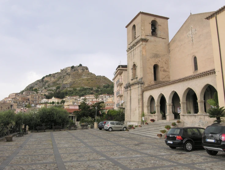 several cars sit parked in front of a large church