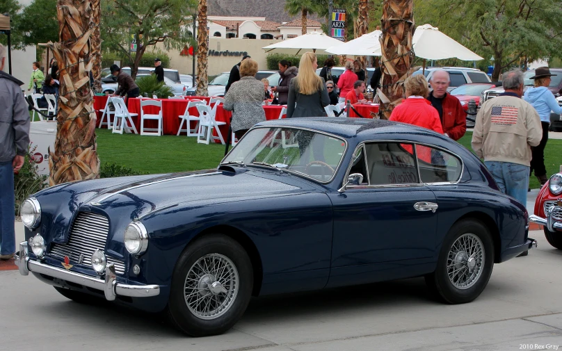 a blue automobile sitting next to another classic car