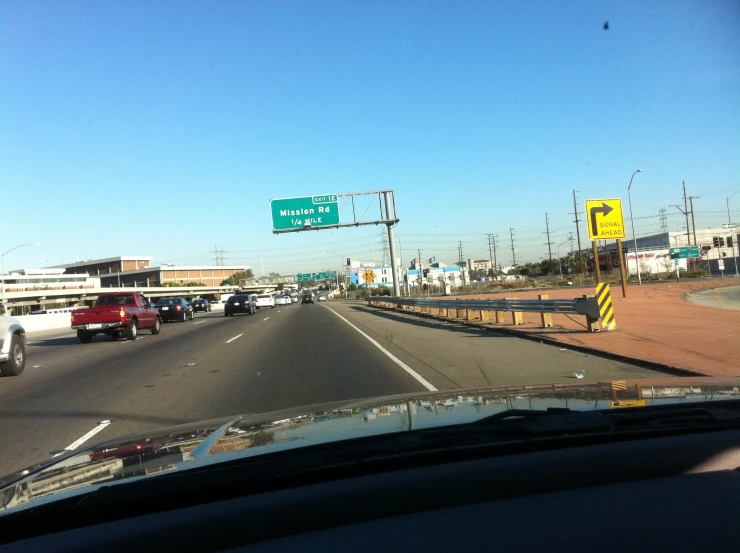 the view from inside a car shows highway signs