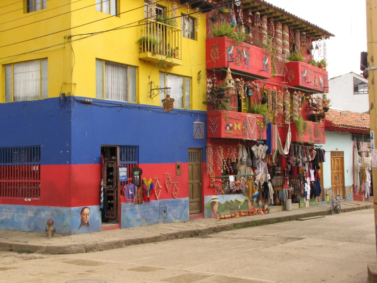 the buildings are colorful in the area and have many things hanging out front