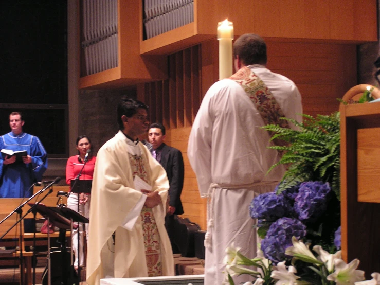 a priest is lighting candles at the alter
