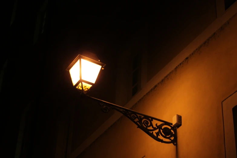a lamp post with an interesting design on it at night