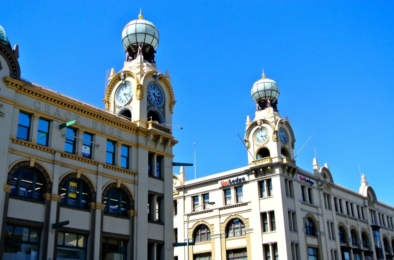 two large buildings with clocks and lights on top