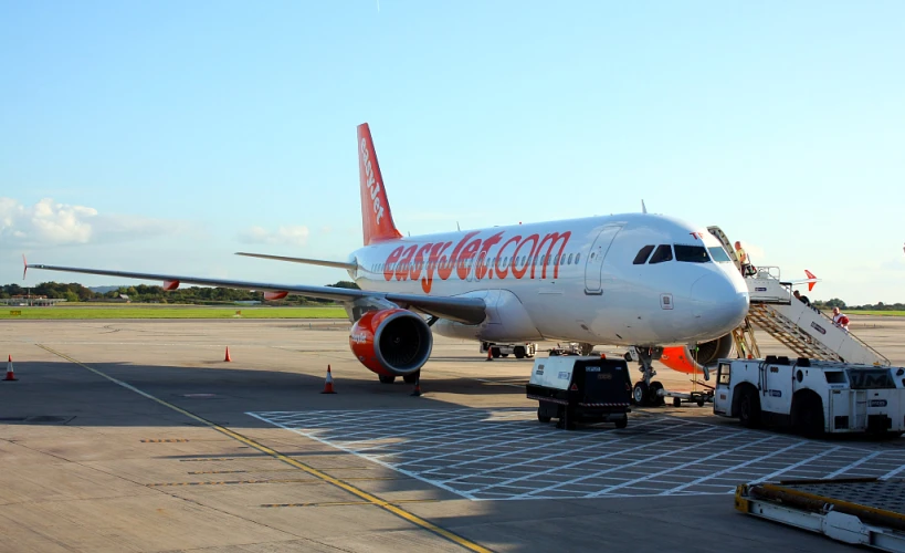 an airplane sits parked at the gate next to the luggage rack