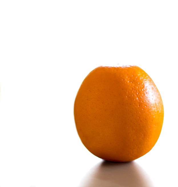 a closeup view of an orange with only one bite taken