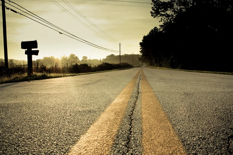 an empty street sits next to an electrical power pole