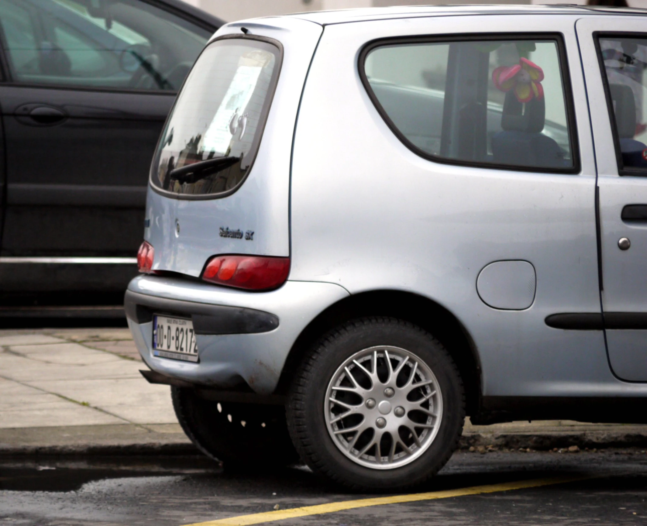 a car parked next to two cars in a parking space