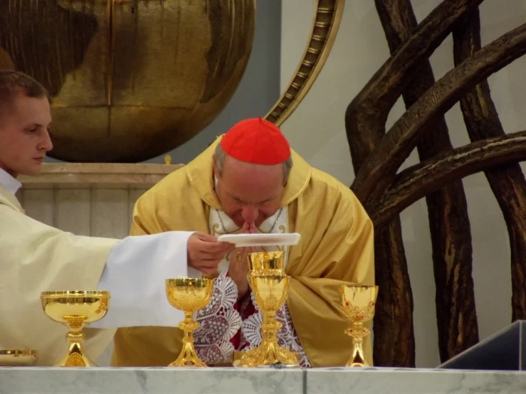 two priests who are holding their hands to each other