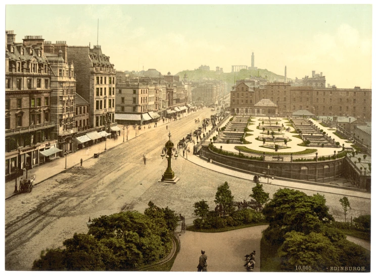 an aerial view of a city square looking toward a fountain and buildings