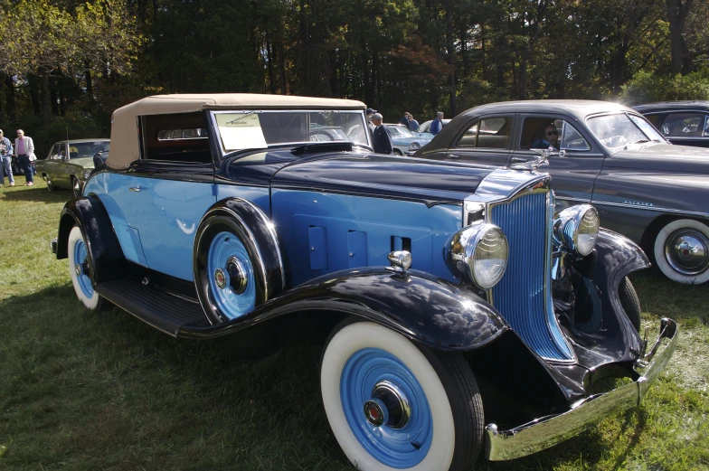 antique cars sitting on display at a car show