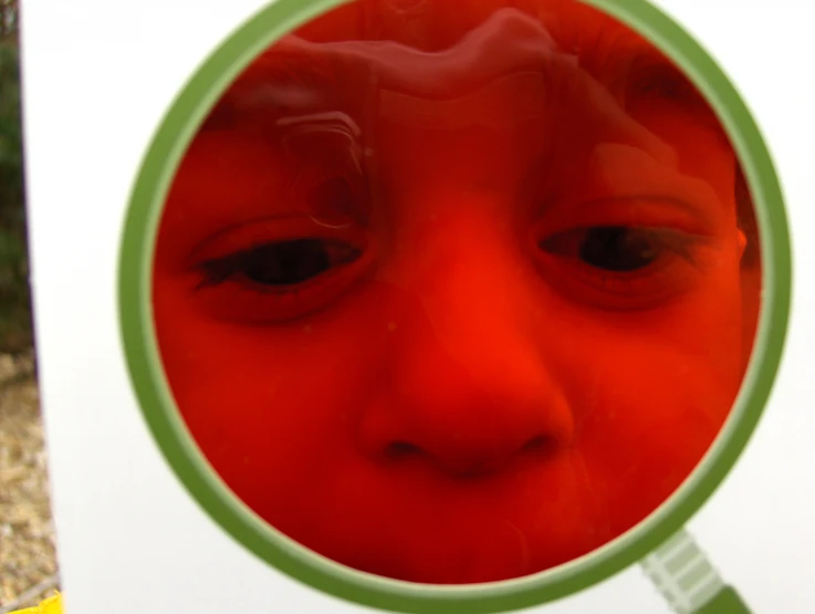 a close up of the face and forehead of a young person looking through a magnifying glass