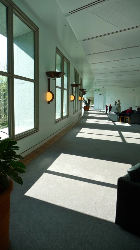 a long hallway with sun streaming in through windows