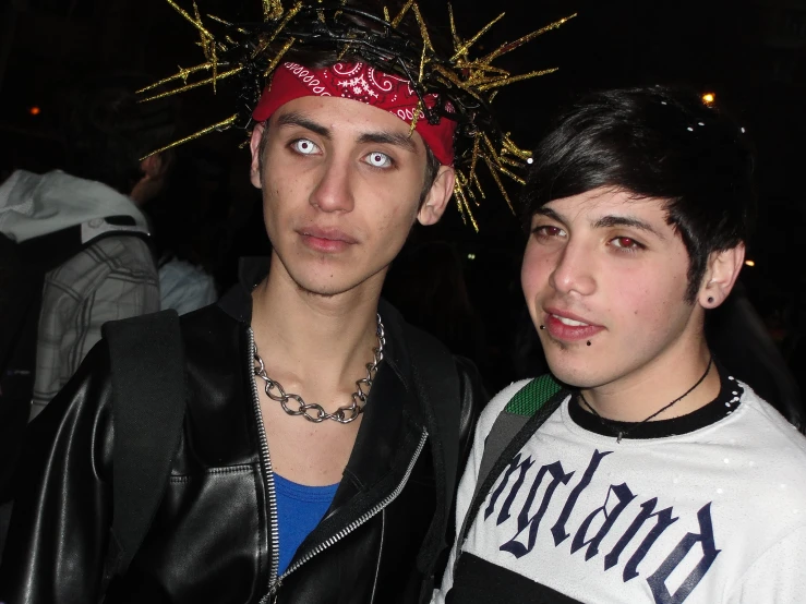 two young men wearing headgear stand next to each other