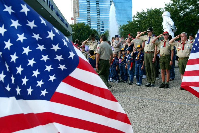 several uniformed officers salute at flags as they observe each other