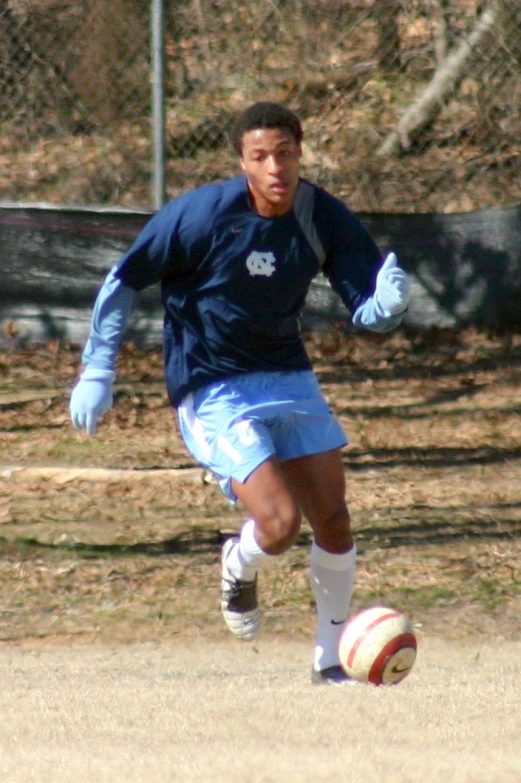 a  kicking a soccer ball around a field