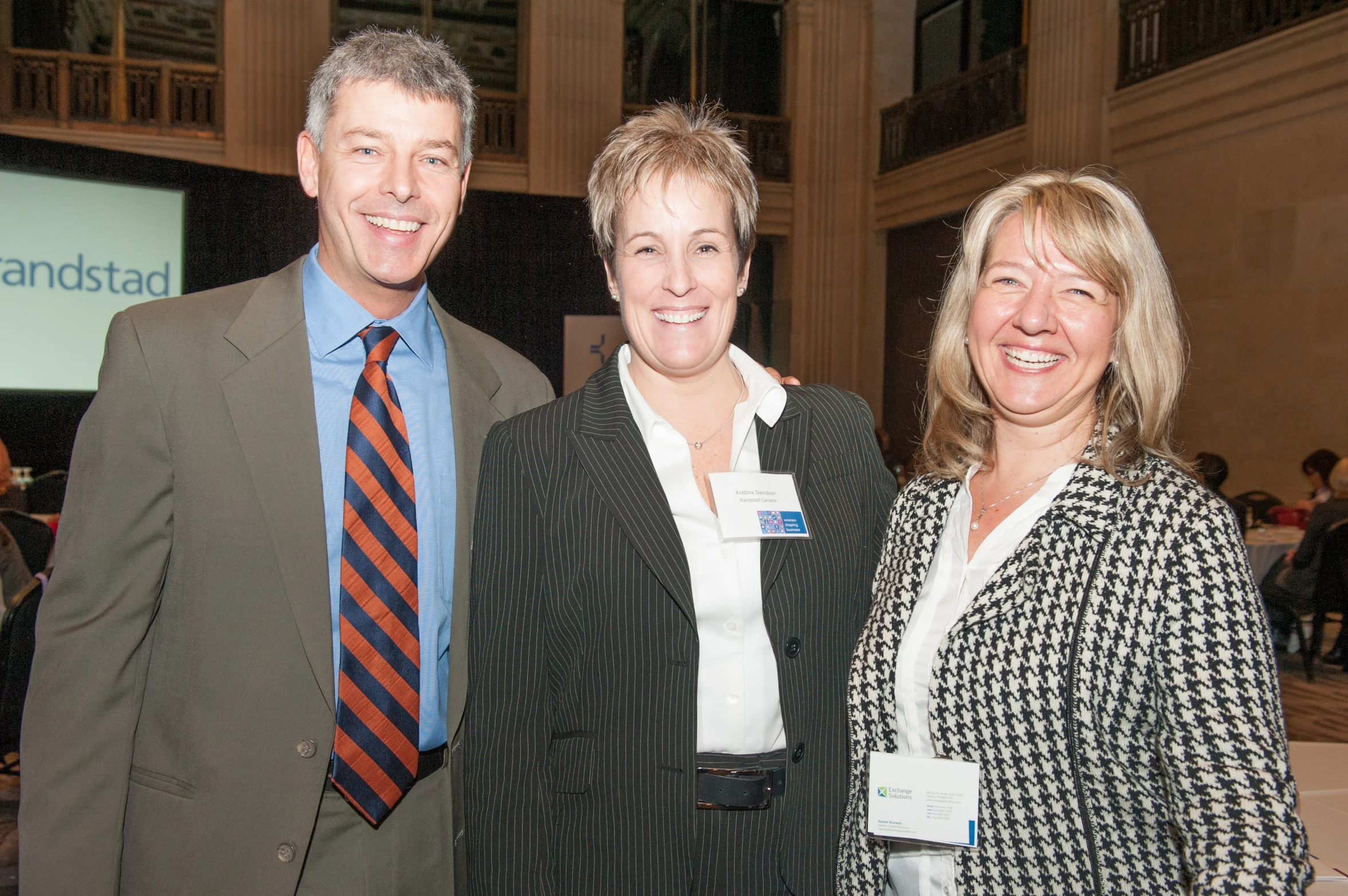 two people and one is wearing a suit and smiling