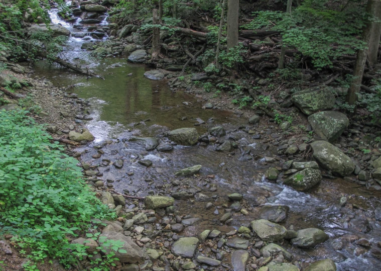 the water is running under the bridge over the rocks