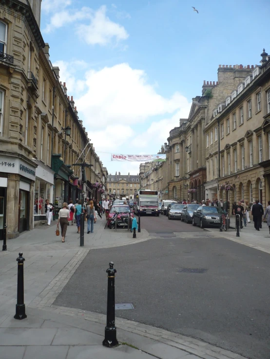 many people walking on the sidewalk of a street