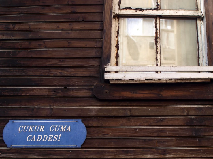 an old building with a sign and wooden siding