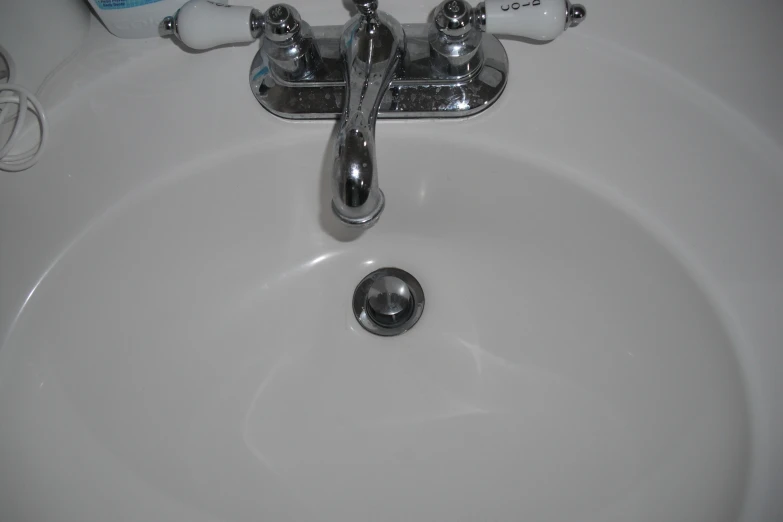 a close s of a sink with soap dispenser and shampoo