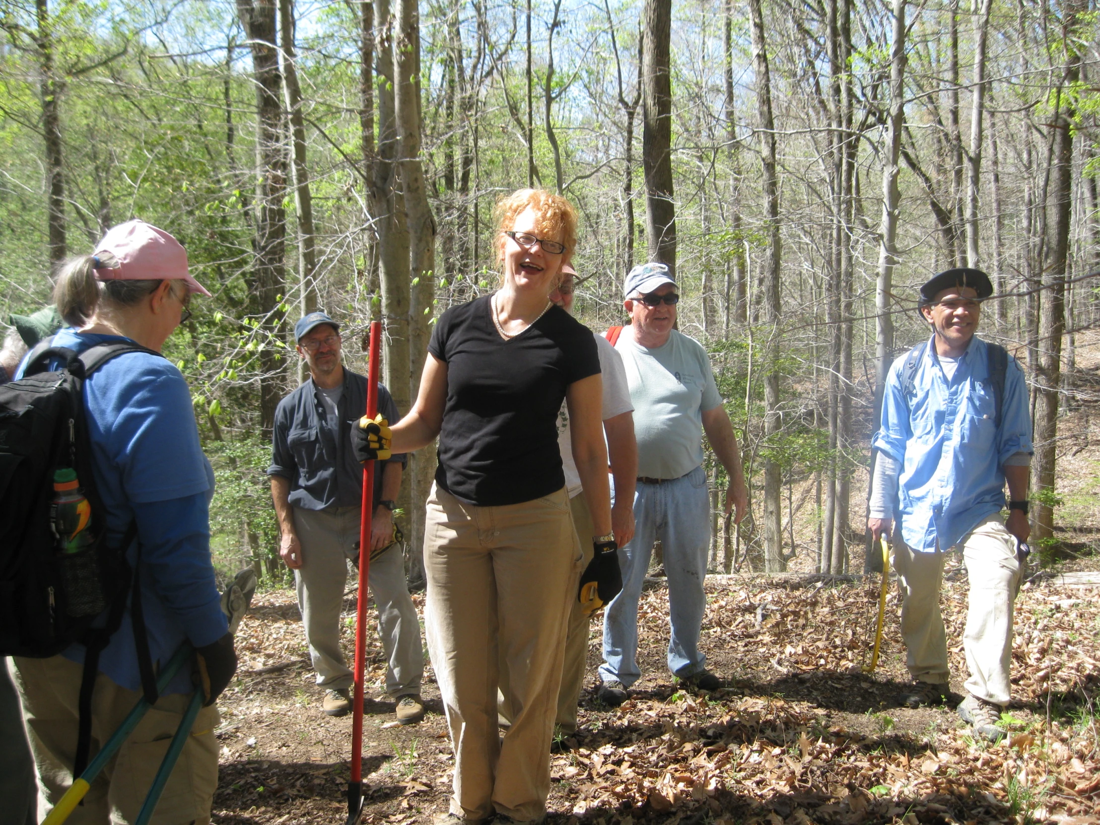 several people gathered in the woods with trees